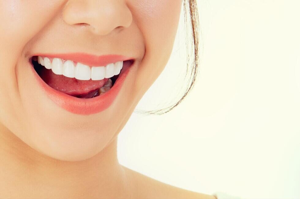 歯が見えるように口を開けている口元