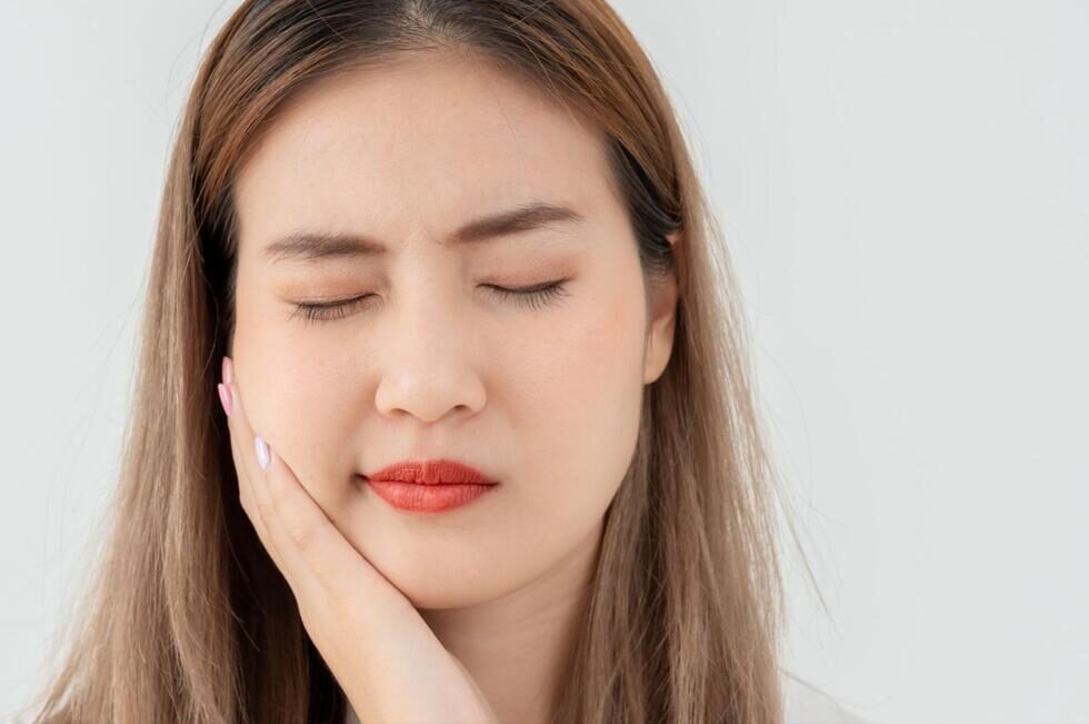 頬を抑える女性