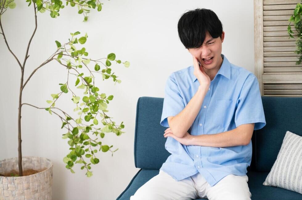 頬を抑えて痛そうにする男性