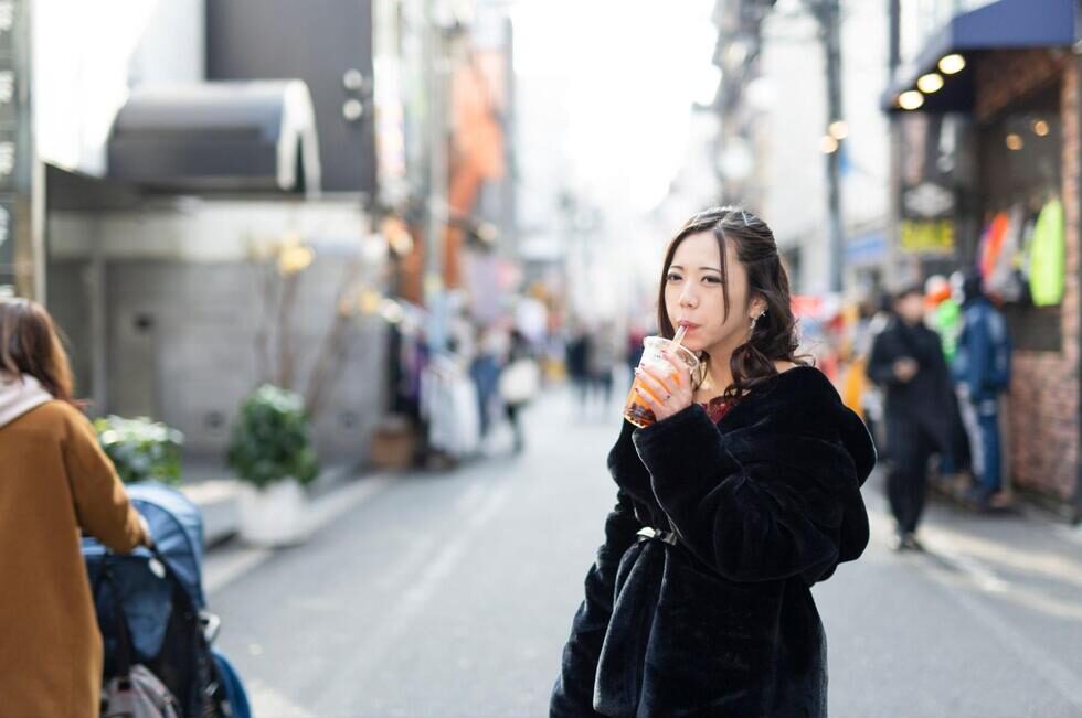 ストローを使って飲み物を飲んでいる女性