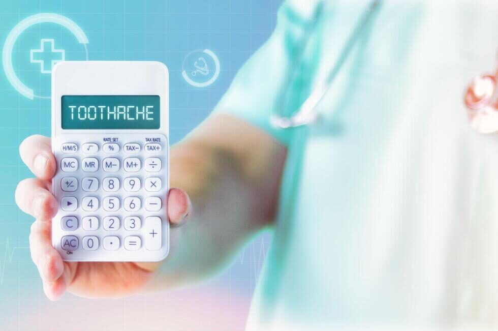 「TOOTHACHE」と表示された電卓を手に持って見せている様子