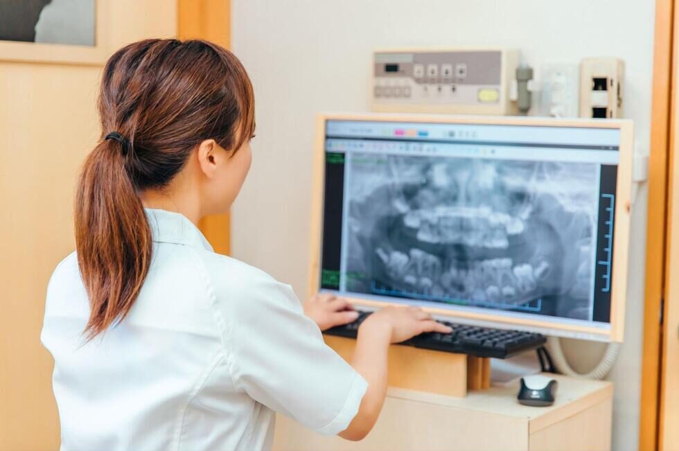 パソコンで歯のレントゲン画像を確認する歯科医師