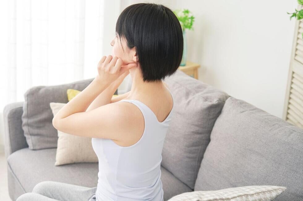 顎を手で触れて顎関節症のセルフチェックをしている