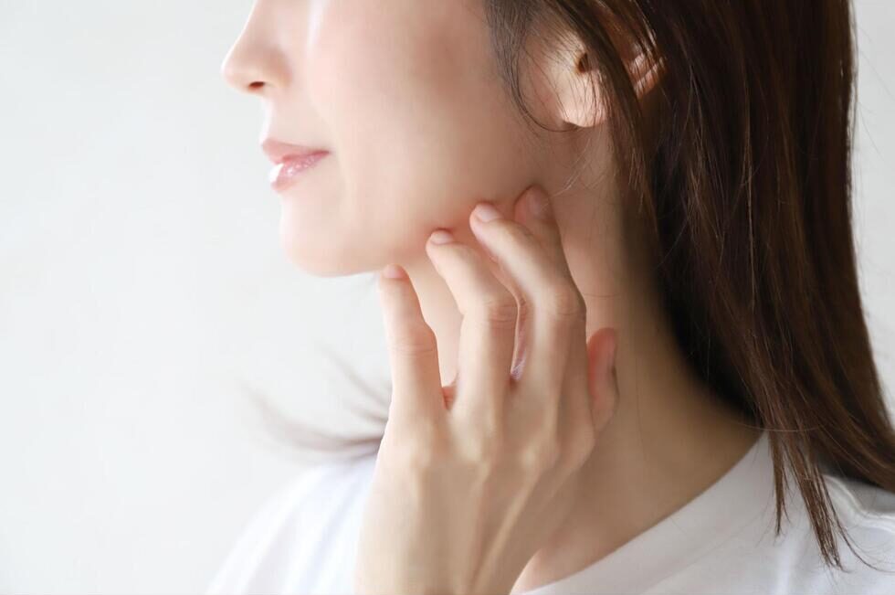 顎の輪郭に手を添えている