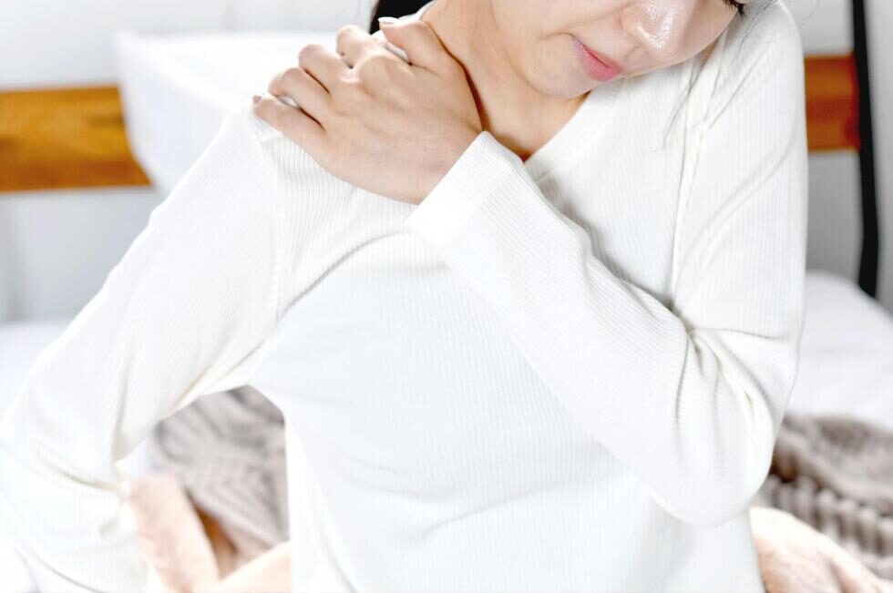 肩を手で押さえている