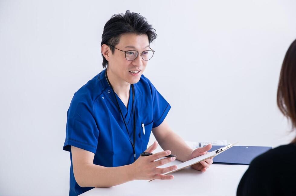 診察室で説明をする歯科医師